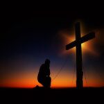 Kneeling and Praying under the Cross